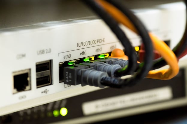 Several ethernet cables are plugged into a network switch.