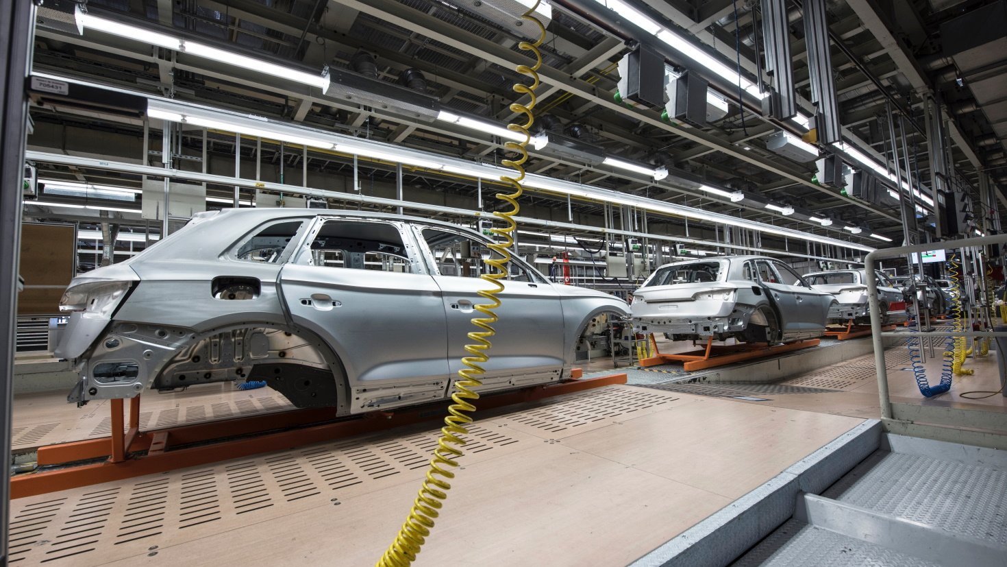 Cars move down a factory assembly line